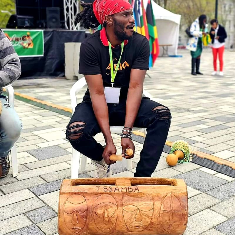 AfriCa Fest - A man is seated and playing an instrument.