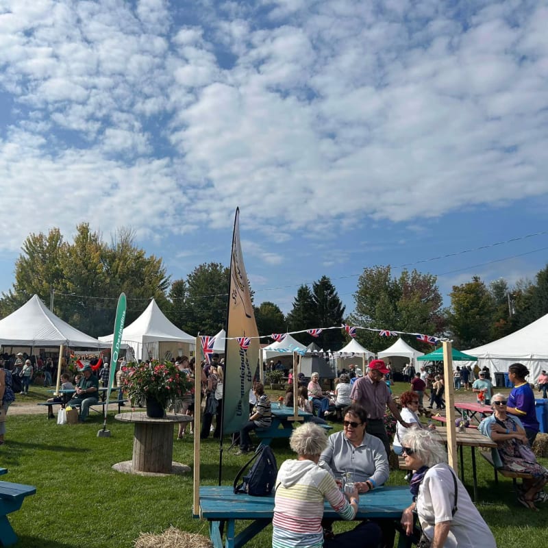 Festival des artisans de Sainte-Marcelline-de-Kildare - Un espace avec des tables de pique-nique et des chapiteaux blancs