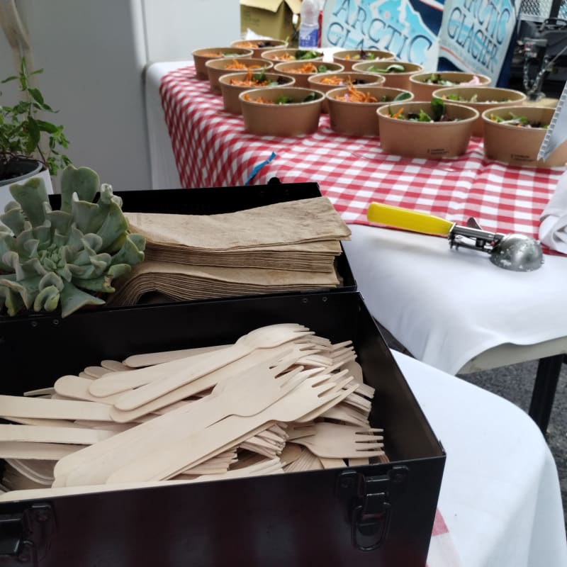 Close-up of wooden utensils and compostable bowls.