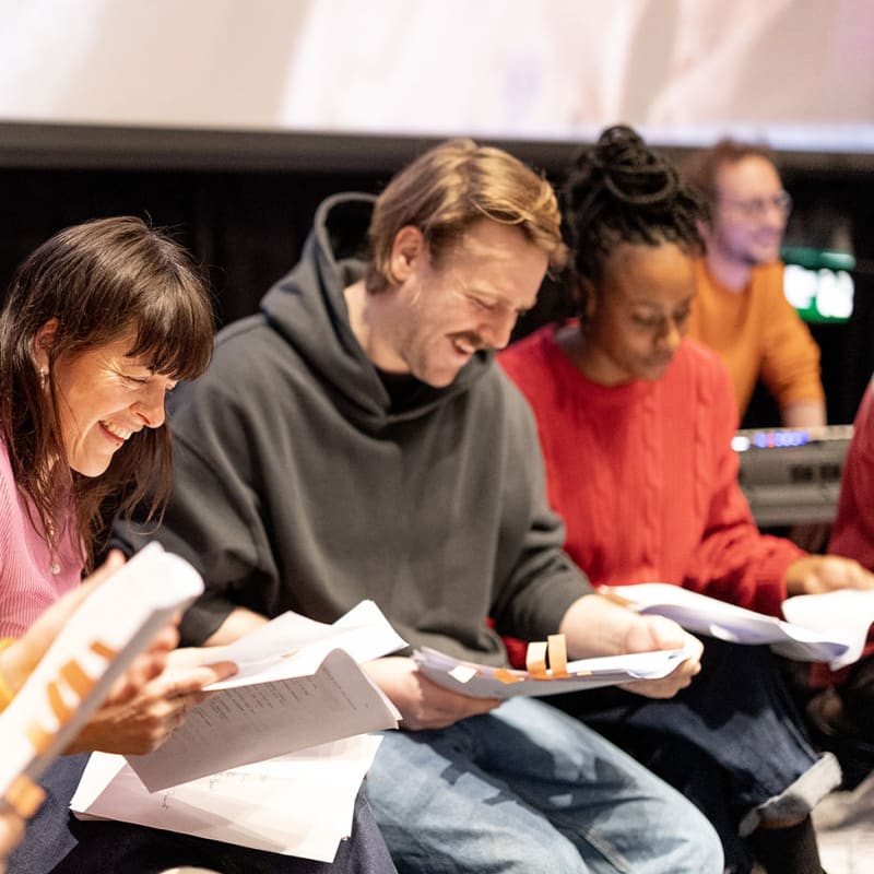 Festival Plein(s) Écran(s) - Un groupe de personnes assises côte à côte, penchées sur des scripts