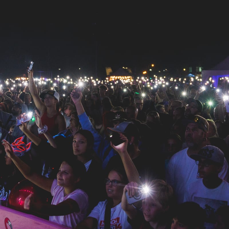 A crowd with their phone lights on during a show at the Festival POP ton été