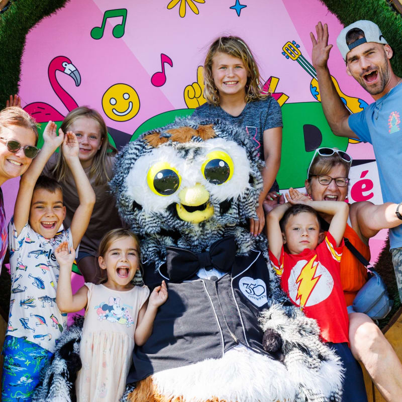 A family having fun with a mascot at the Festival POP ton été