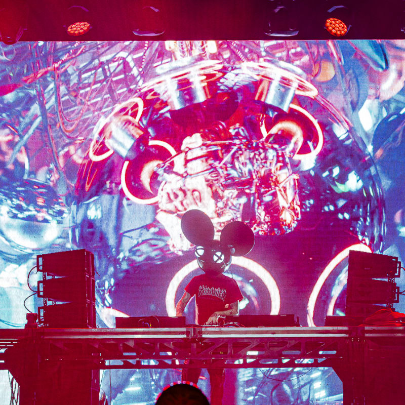 Riverside Festival - DJ on stage with colored lights behind.