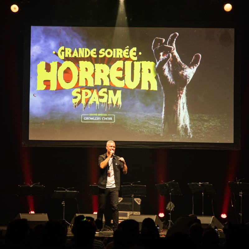 Festival SPASM - Un homme utilise un microphone sur une scène.