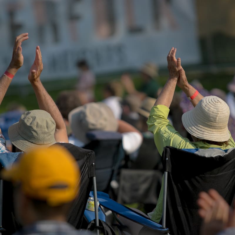 Festival SuperFolk Morin-Heights - Des personnes sont assises sur des chaises de camping. Deux personnes applaudissent.
