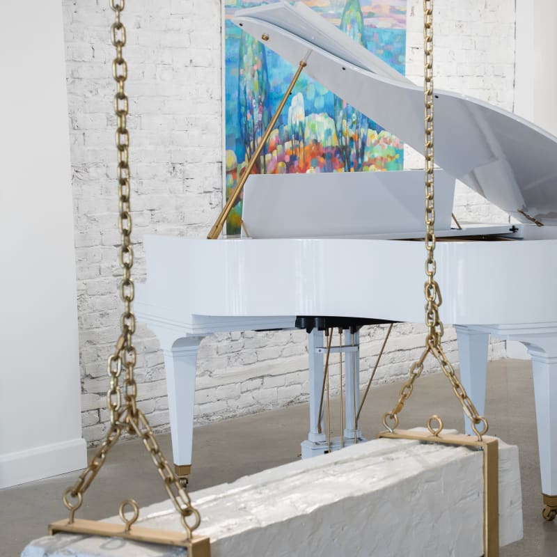 Galerie Angelina - Une balançoire suspendue, un piano blanc et un œuvre d'art accroché au mur
