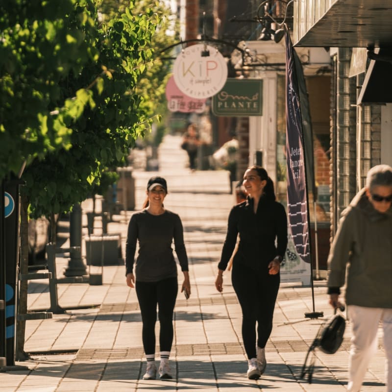 Two women walking in the Magog village.