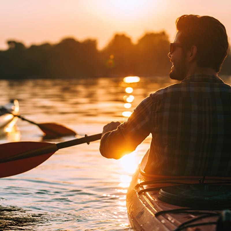 Couple en kayak au coucher du soleil.