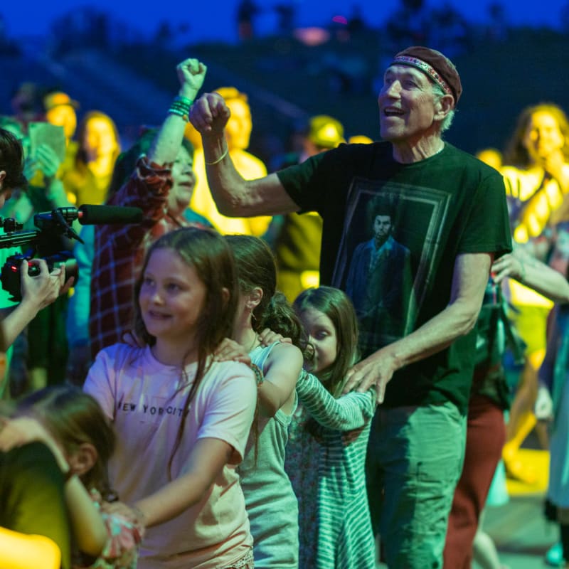 Group of adults and kids at an Indigenous music show.