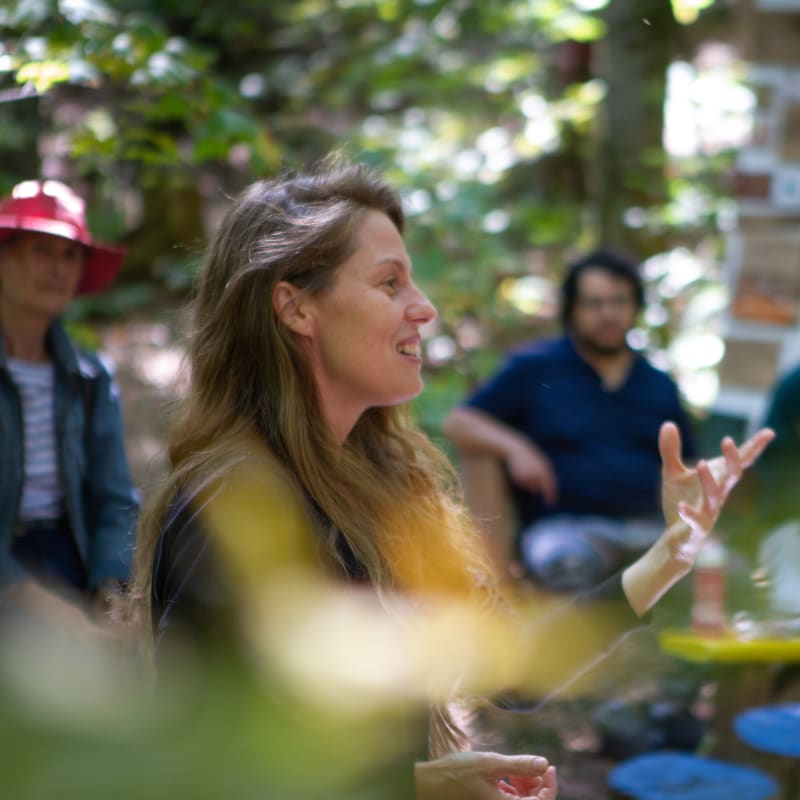 Les Correspondances d’Eastman - Une femme souriante semble s'exprimer devant un petit public