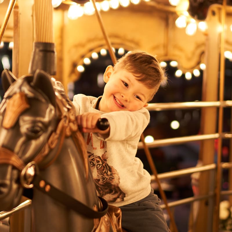 Garçon sur un cheval de carrousel au Méga Parc.