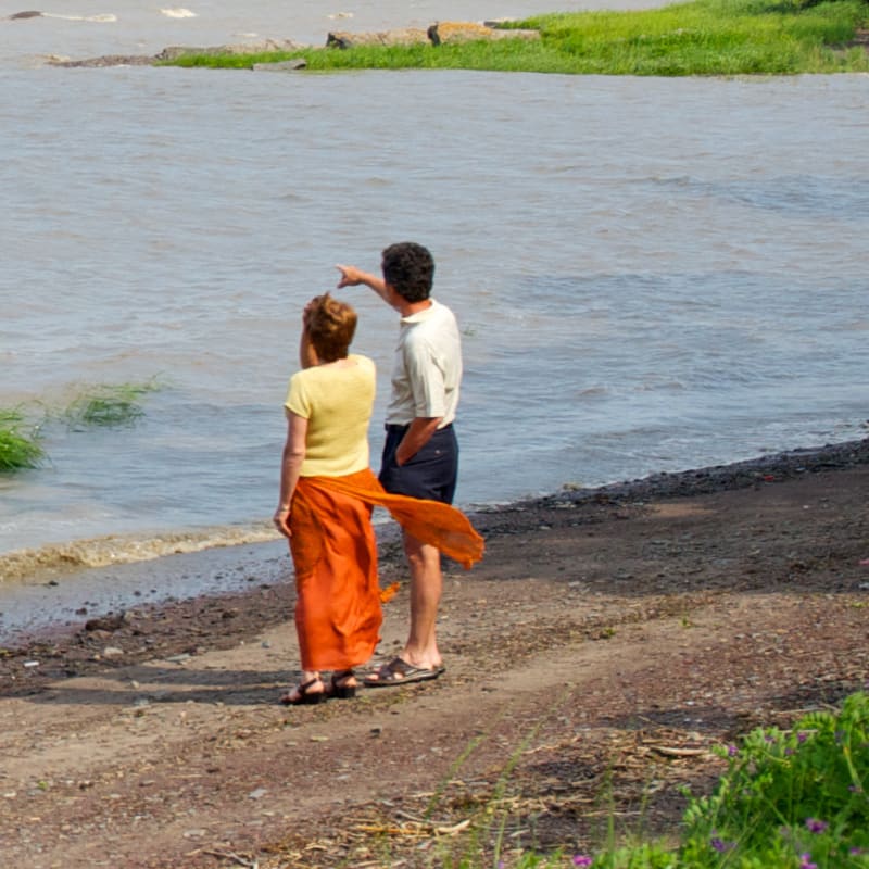 Couple by the water looking at the river.