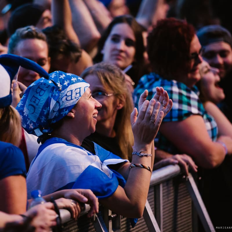Crowd at a Saint-Jean-Baptiste Day celebration with Quebec flags.
