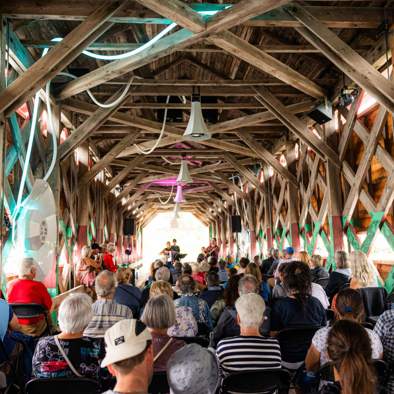 Audience seated in a barn converted into a performance venue.
