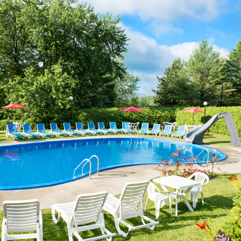 Outdoor in-ground pool surrounded by sun loungers.
