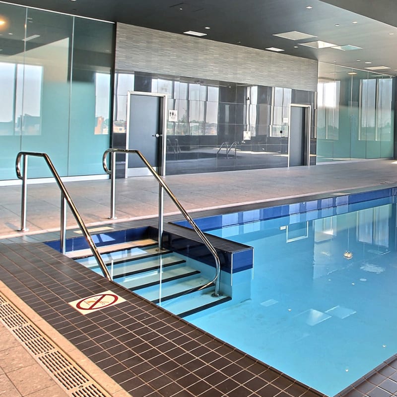 Piscine intérieure de l'hôtel dans une salle vitrée.