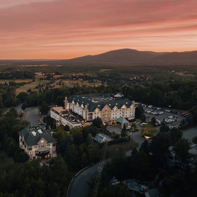 Panoramic view of Domaine Château-Bromont with the golf course and mountain in the background