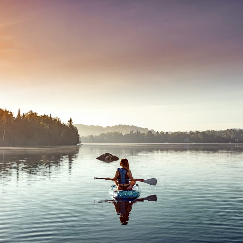 Woman on the lake on a paddleboard at Estérel Resort.