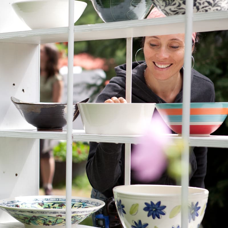 Smiling woman looking at ceramic bowls.