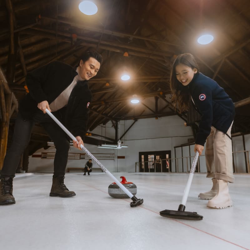 Deux personnes en train de jouer au curling.