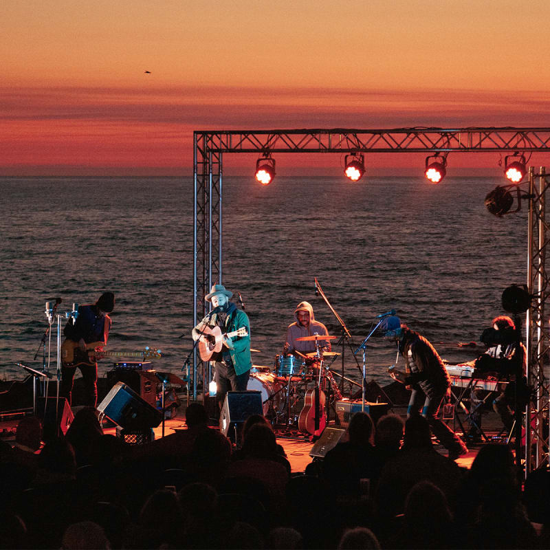Musiciens sur la scène lors d'un spectacle au coucher de soleil
