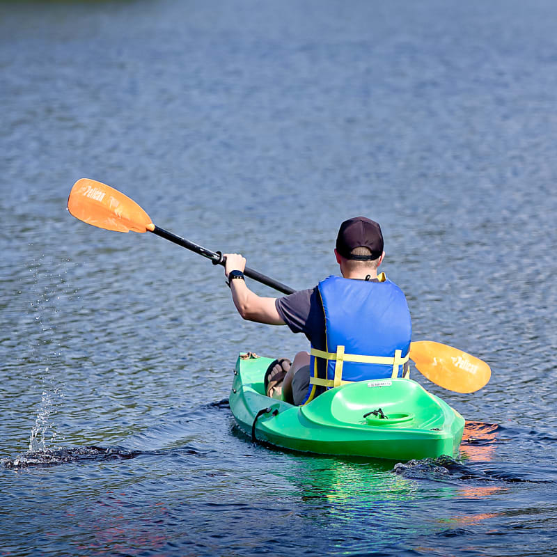 Man seen from the back kayaking on the private lake.