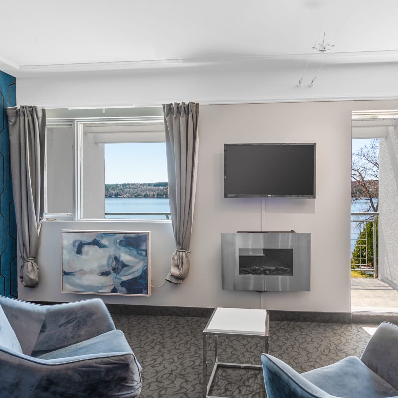Chambre du Manoir Lac-Etchemin avec la porte du balcon ouverte sur le vue du lac.