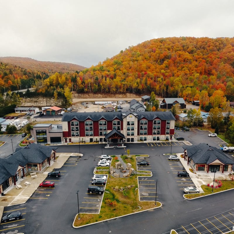 Front view of the Microtel Inn in Tremblant with a background of fall foliage.