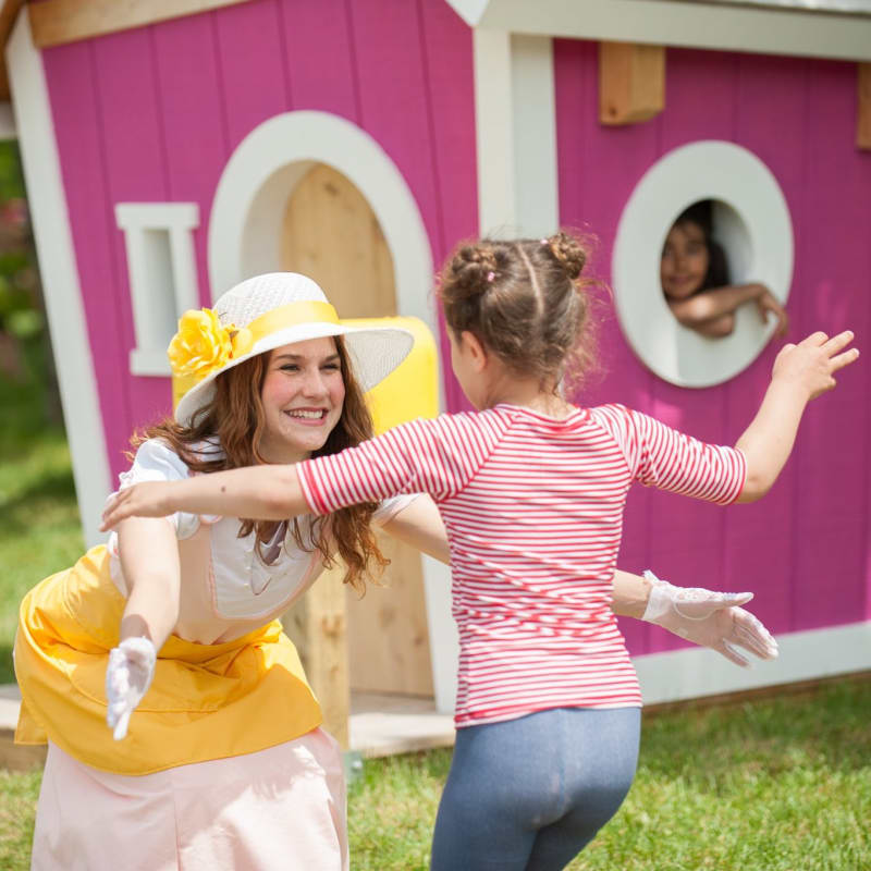 A park staff member about to give a hug to a young visitor.