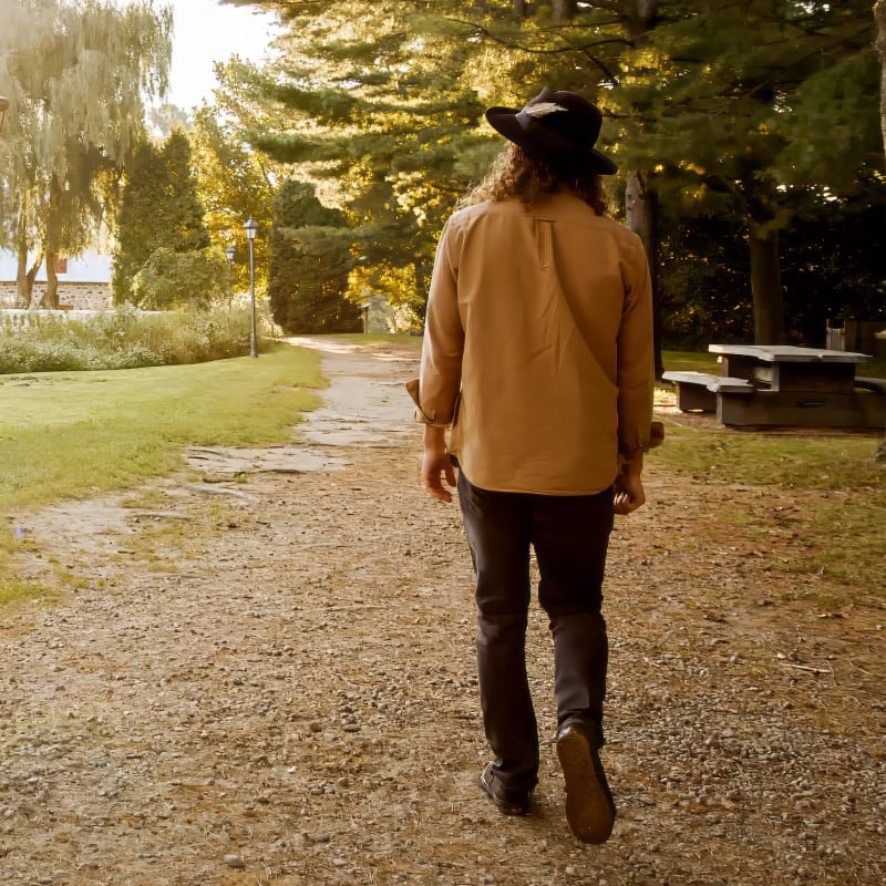 A person facing away from the camera, walking on the nature trails.