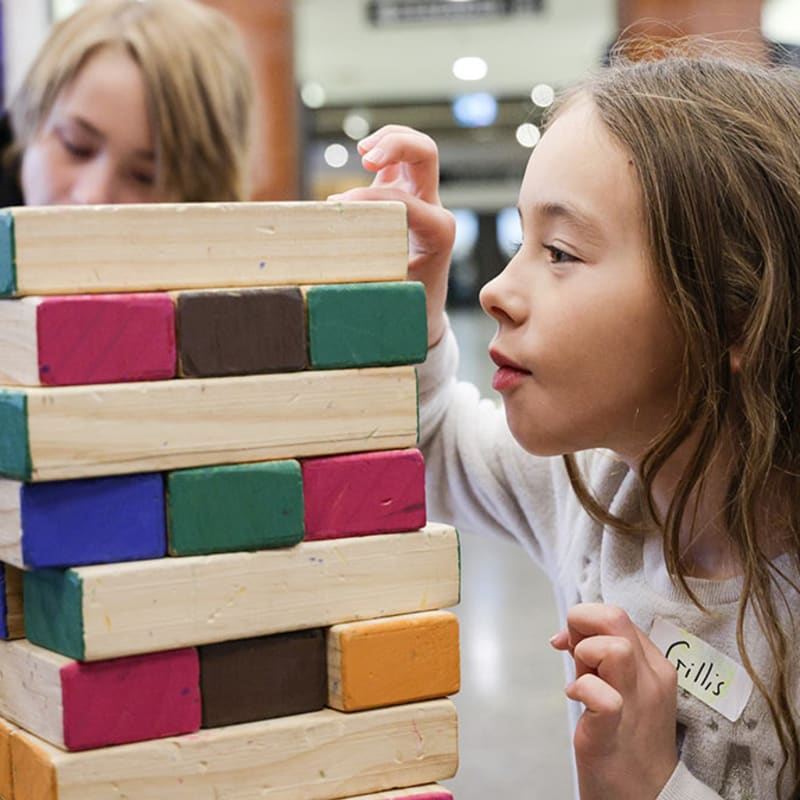 Two kids playing a Jenga game at the musem.