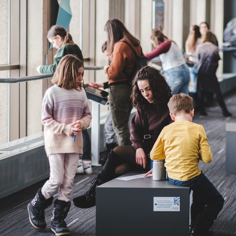 Parents et enfants à l'exposition de l'observatoire de la capitale.