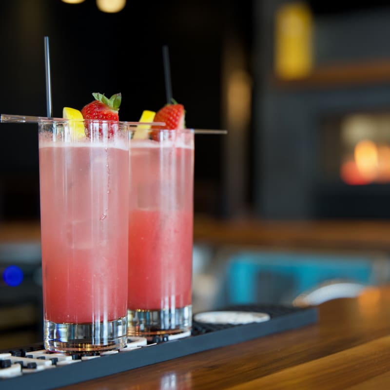 Two fruity cocktails on a counter at a resto-bar