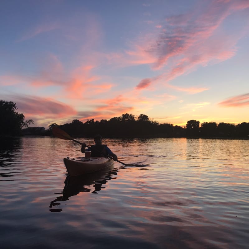 Personne en kayak sur la rivière au crépuscule.