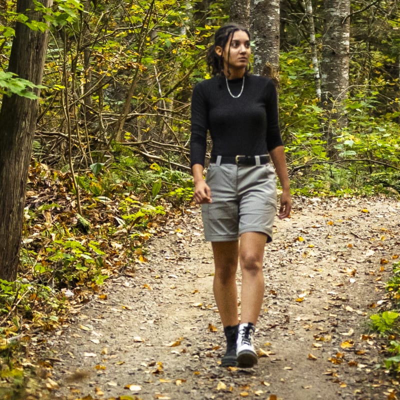 Young woman on a hiking trail in the forest in the fall