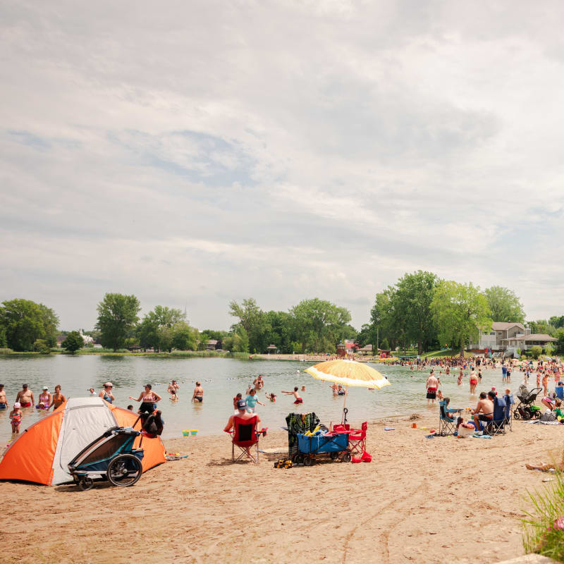 A golden-sand beach with dozens of beach-goers.