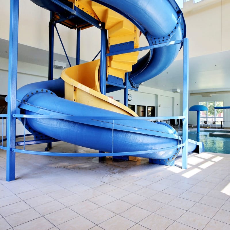 Indoor pool with blue and yellow slide at Super 8 Lachenaie.