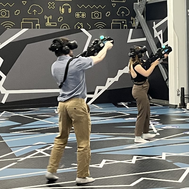Three people in a virtual reality arena.