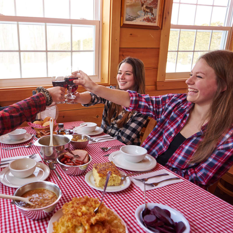 Group of four people raising their wine glass at the sugar shack.