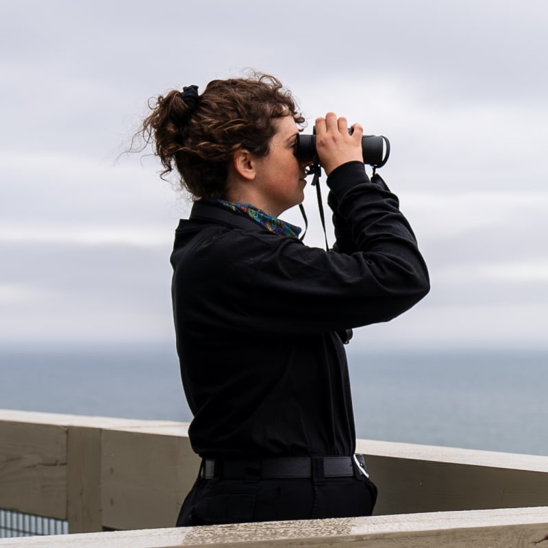 Woman looking at  the sea with binoculars.