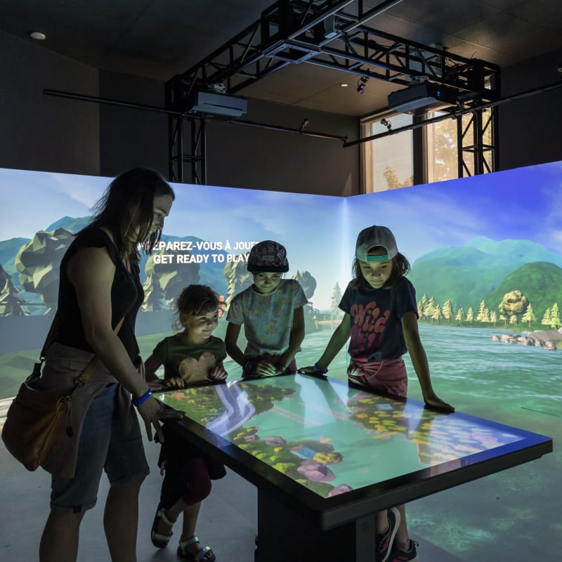 4 kids around an interactive display at the Acoatica exhibit.