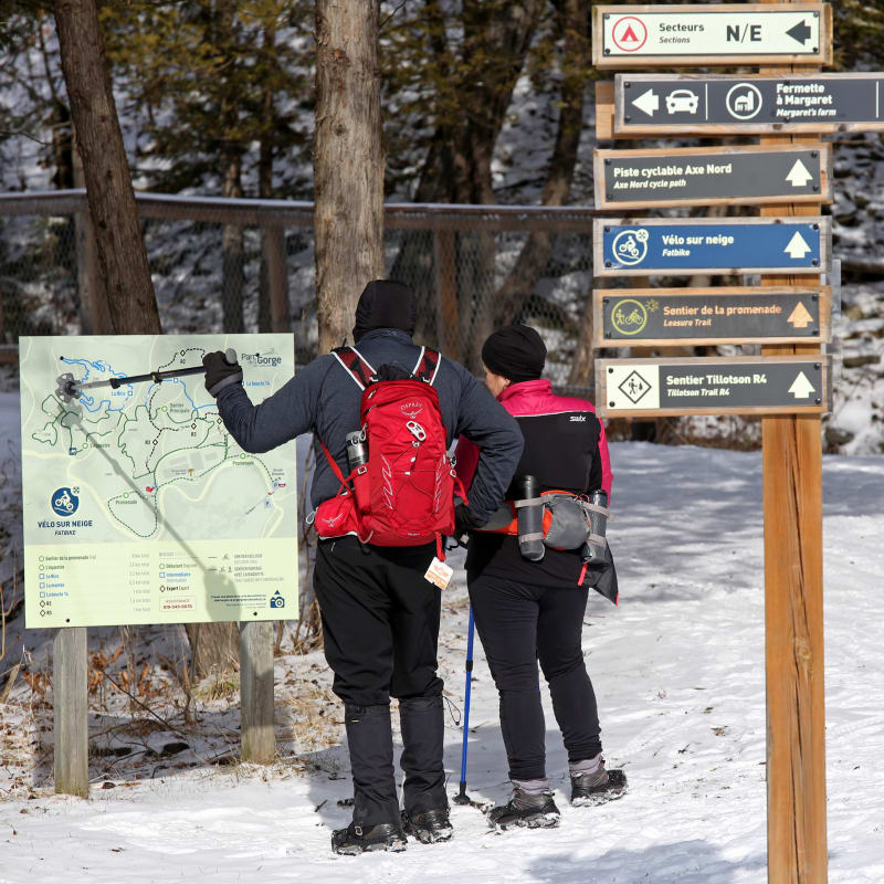 A man and a woman hiking in the winter at the Coaticook Gorge Park.