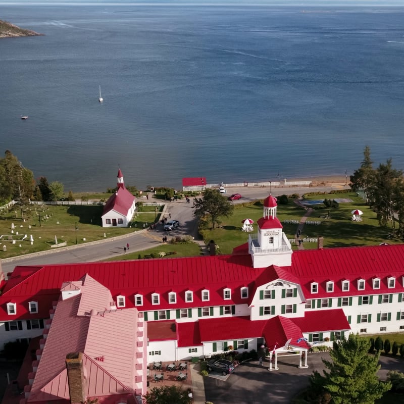 Aerial view of a red-roofed waterfront hotel.