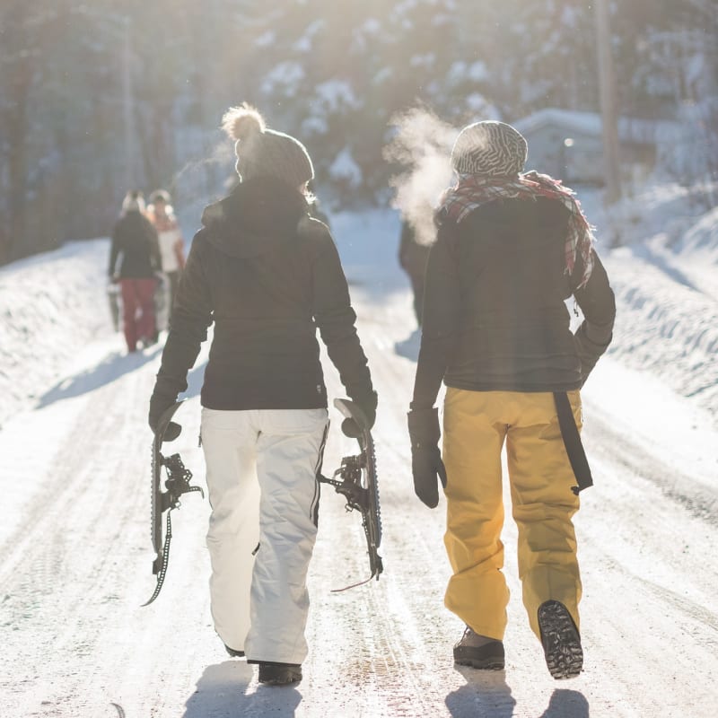 Couple in snowsuits on a snowshoe trail.
