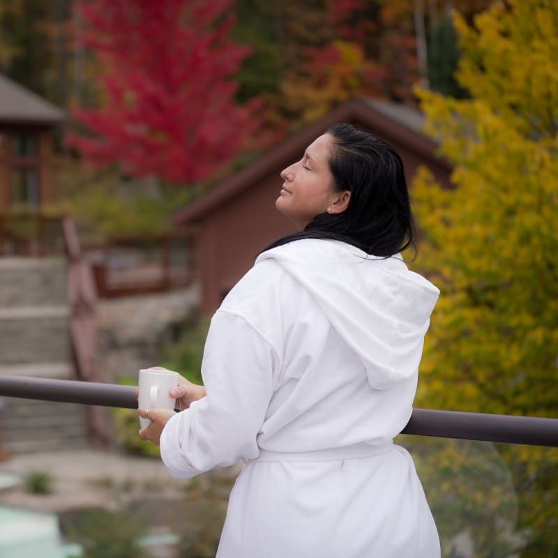 Femme en robe de spa sur le bord des installations thermales.