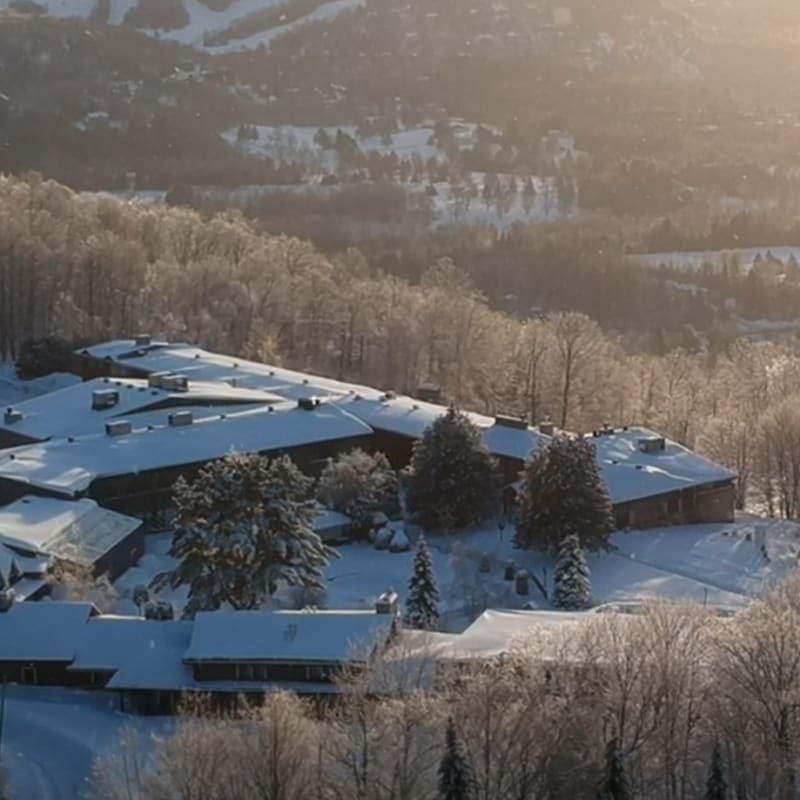 Aerial view of Hotel Mont-Gabriel with a ski area in the background.