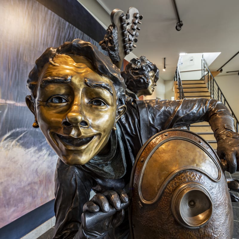 Close-up of a bronze work depicting a smiling person.
