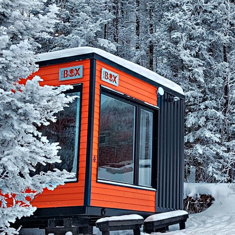 Colourful Coolbox accommodations in a snowy setting.