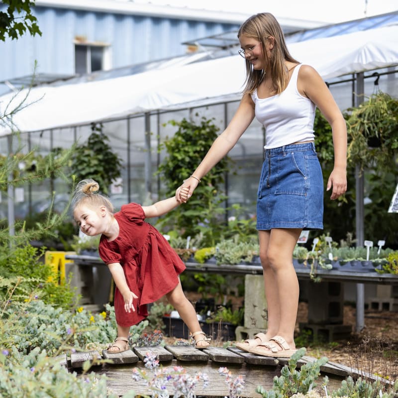 Two young girls observing a cactus and succulent garden.
