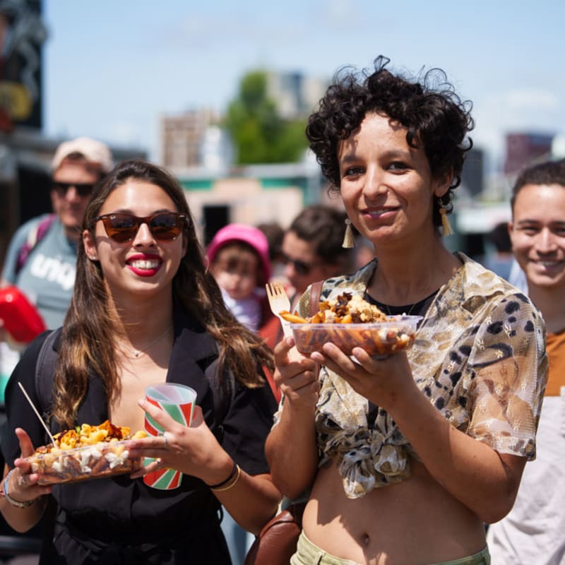 Two festival-goers with street food in hand.